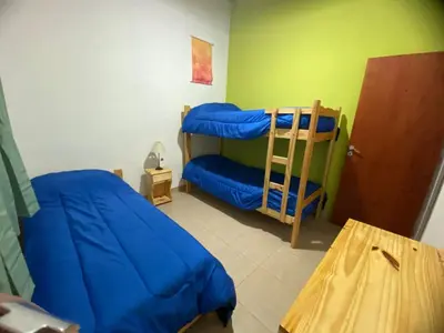 a bedroom with two bunk beds and a table at Casitas Del Champaqui in Villa Yacanto