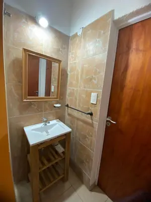a bathroom with a sink and a wooden door at Casitas Del Champaqui in Villa Yacanto