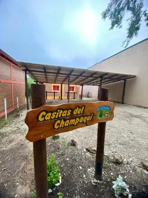 a wooden sign in front of a building with a roof at Casitas Del Champaqui in Villa Yacanto