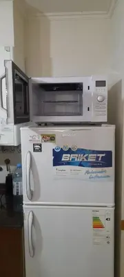a microwave on top of a refrigerator in a kitchen at Miralejos 2 in Villa Carlos Paz