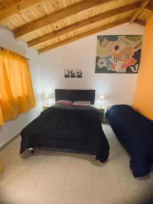 a bedroom with a large black bed and two lamps at Casitas del Champaqui in Villa Yacanto