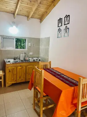 a kitchen with an orange table and a sink at Casitas del Champaqui in Villa Yacanto