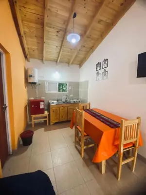 a kitchen with a table and chairs in a room at Casitas del Champaqui in Villa Yacanto