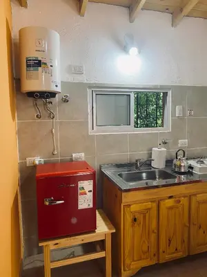 a kitchen with a sink and a red box at Casitas del Champaqui in Villa Yacanto