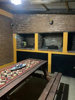 a kitchen with a table and a brick wall at Casitas del Champaqui in Villa Yacanto