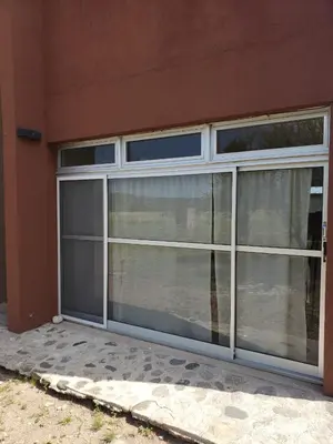 a sliding glass door on the side of a building at Miradores del Dique in San Francisco del Monte de Oro
