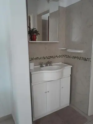 a bathroom with a white sink and a mirror at Departamento Carolina in Villa Carlos Paz