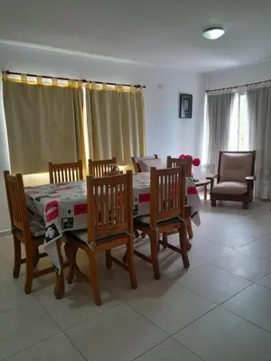 a dining room with a table and four chairs and a table and chairsktop at Departamento Carolina in Villa Carlos Paz