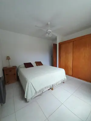 a bedroom with a bed and a ceiling fan at Departamento Carolina in Villa Carlos Paz