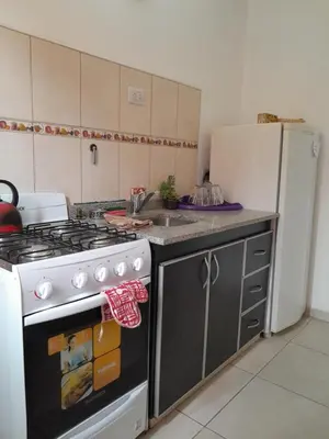 a kitchen with a stove and a refrigerator at Departamento Carolina in Villa Carlos Paz
