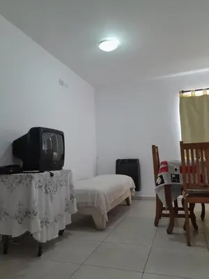 a room with a bed and a tv on a table at Departamento Carolina in Villa Carlos Paz
