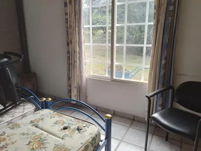 a bed and a chair in a room with a window at La Nora in Cuesta Blanca
