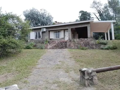 a stone house with a fence in front of it at La Nora in Cuesta Blanca