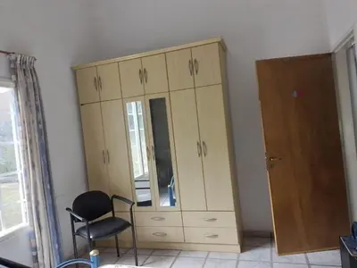 a wooden cabinet and a chair in a room at La Nora in Cuesta Blanca