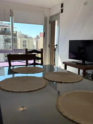a living room with a glass table and a television at Cañada 12 depto 1 dormitorio pax 3 in Cordoba