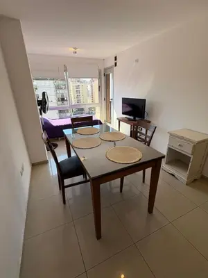 a living room with a table and chairs and a television at Cañada 12 depto 1 dormitorio pax 3 in Cordoba