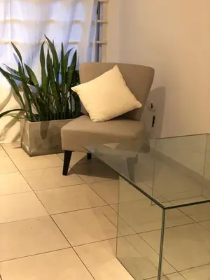 a chair with a pillow sitting next to a glass table at Chacabuco 3 Depto 1 dormitorio PAX 4 Nueva Cordoba in Cordoba