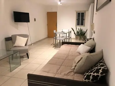 a living room with a bed and a dining room at Chacabuco 3 Depto 1 dormitorio PAX 4 Nueva Cordoba in Cordoba