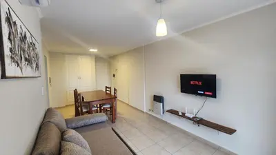 a living room with a couch and a tv on a wall at Nazareno depto 1 dormitorio Guemes PAX 4 in Cordoba