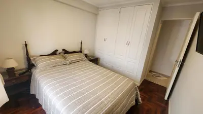 a bedroom with a bed with a striped comforter at Nazareno depto 1 dormitorio Guemes PAX 4 in Cordoba