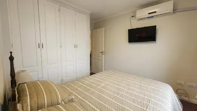 a bedroom with a bed and a tv on the wall at Nazareno depto 1 dormitorio Guemes PAX 4 in Cordoba