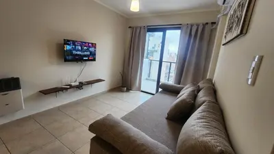 a living room with a couch and a tv at Nazareno depto 1 dormitorio Guemes PAX 4 in Cordoba