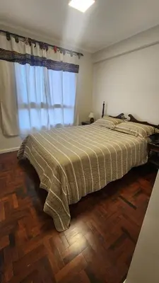 a bedroom with a bed with a large window at Nazareno depto 1 dormitorio Guemes PAX 4 in Cordoba