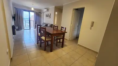 a dining room and living room with a table and chairs at Nazareno depto 1 dormitorio Guemes PAX 4 in Cordoba