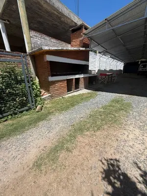 a patio of a house with a table and a building at Hosteria las Palmeras in Mina Clavero
