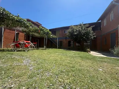 a yard with a red table in front of a building at Hosteria las Palmeras in Mina Clavero