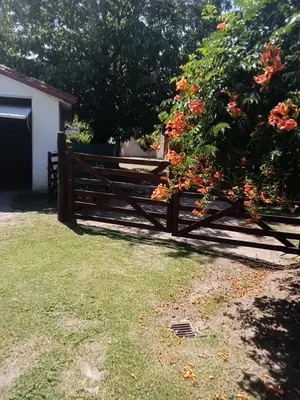 a wooden fence in front of a house with flowers at Complejo La Tere- depto 2 in Cordoba