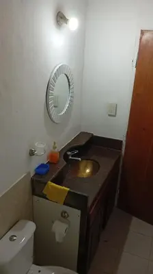 a bathroom with a sink and a mirror and a toilet at Complejo La Tere- depto 2 in Cordoba
