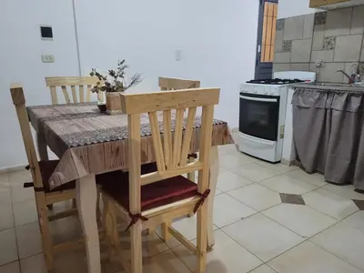 a kitchen with a wooden table with chairs and an oven at Mate host in Cordoba