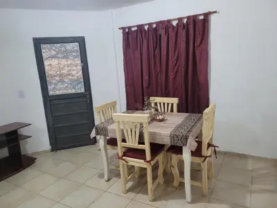 a dining room with a table and chairs and a window at Mate host in Cordoba