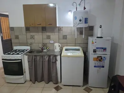 a kitchen with a sink and a stove and refrigerator at Mate host in Cordoba