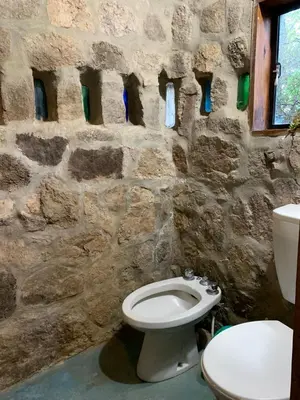 a stone bathroom with a toilet and a sink at El Jopi in Tanti