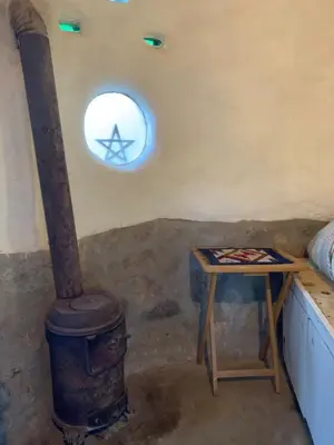 a room with a stove and a table and a window at El Jopi in Tanti
