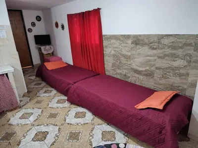 a bed in a room with a red curtain at Lo de Alicia in Santa Rosa de Calamuchita