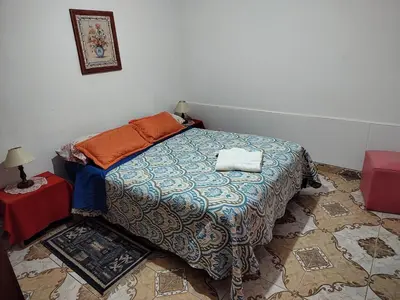 a bedroom with a bed with a blue comforter at Lo de Alicia in Santa Rosa de Calamuchita