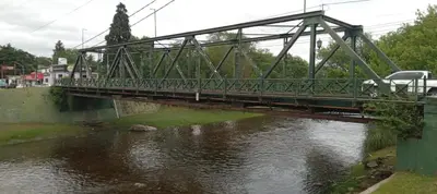 a bridge over a river with a van on it at Lo de Alicia in Santa Rosa de Calamuchita