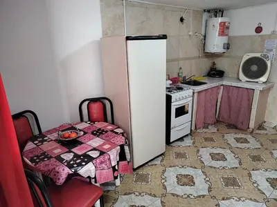 a small kitchen with a table and a refrigerator at Lo de Alicia in Santa Rosa de Calamuchita