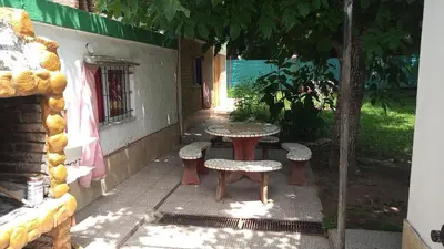 a table and chairs on a patio under a tree at Lo de Alicia in Santa Rosa de Calamuchita