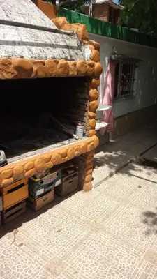a wooden bench sitting on the side of a building at Lo de Alicia in Santa Rosa de Calamuchita