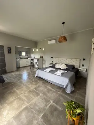 a large bedroom with a bed and a kitchen at SuiteMilSueños in Arroyo de Los Patos