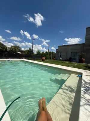 a person laying on the edge of a swimming pool at SuiteMilSueños in Arroyo de Los Patos