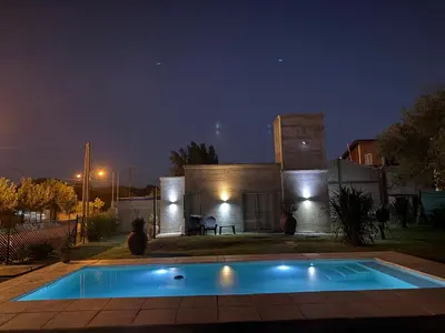 a swimming pool in front of a house at night at SuiteMilSueños in Arroyo de Los Patos