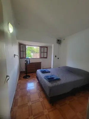 a bedroom with a bed and a desk and a window at Alojamiento Esparta in Villa Carlos Paz