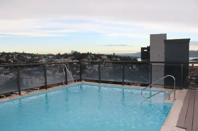 a swimming pool on the roof of a building at Excelente departamento moderno con pileta in Villa Carlos Paz