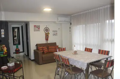 a living room with a table and chairs and a couch at Excelente departamento moderno con pileta in Villa Carlos Paz