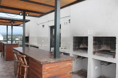 a kitchen with a counter with a fireplace at Excelente departamento moderno con pileta in Villa Carlos Paz